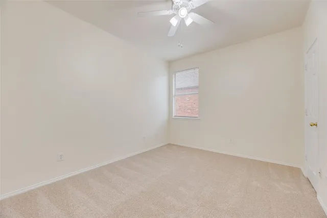 an empty room with a chandelier fan