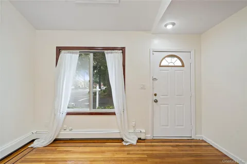 an empty room with wooden floor a ceiling fan and windows