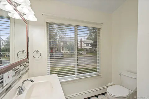 a bathroom with a sink a toilet and a window