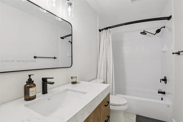 a bathroom with a sink vanity mirror and toilet