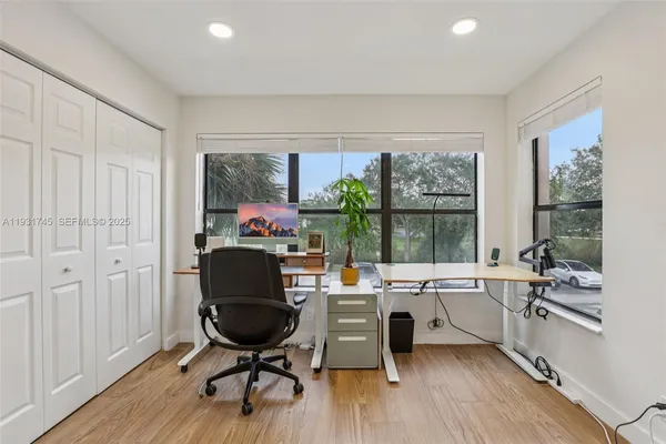 a view of a workspace with furniture and a window