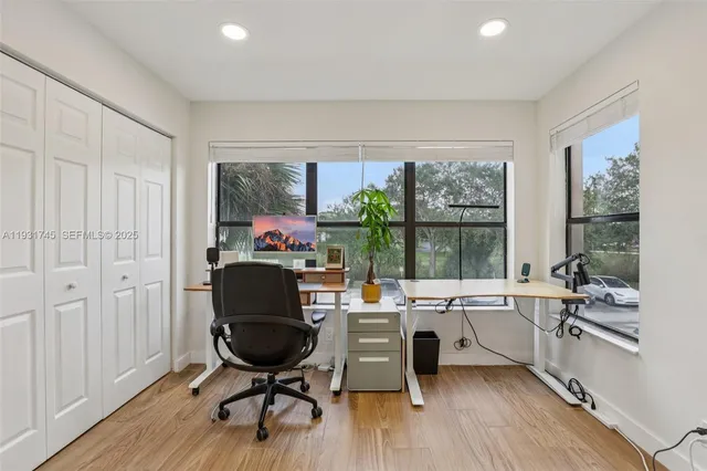 a view of a workspace with furniture and a window