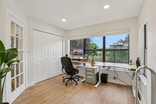 a view of a workspace with furniture and a window
