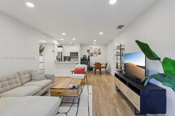 a living room with furniture and wooden floor
