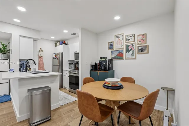 a kitchen with stainless steel appliances granite countertop a dining table and chairs