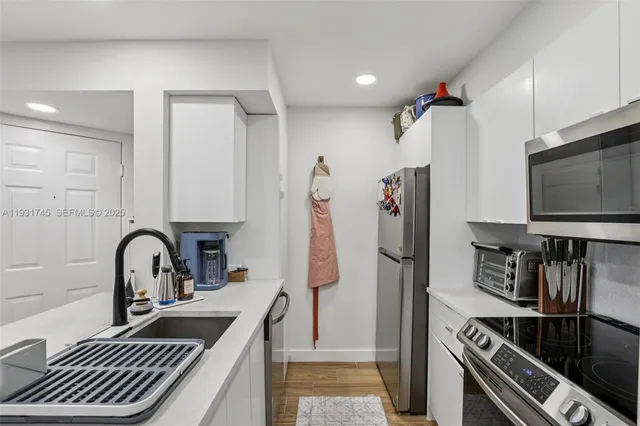a kitchen with stainless steel appliances a sink and a refrigerator