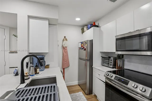 a kitchen with a refrigerator and a sink