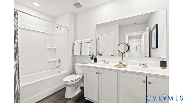 a bathroom with a double vanity sink double mirror bathtub and toilet