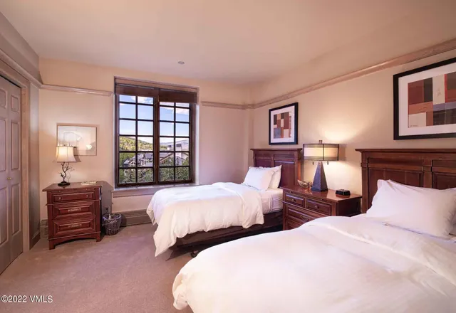 a bedroom with two beds and a window