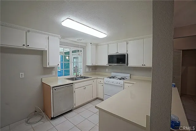 a kitchen with a sink appliances and cabinets