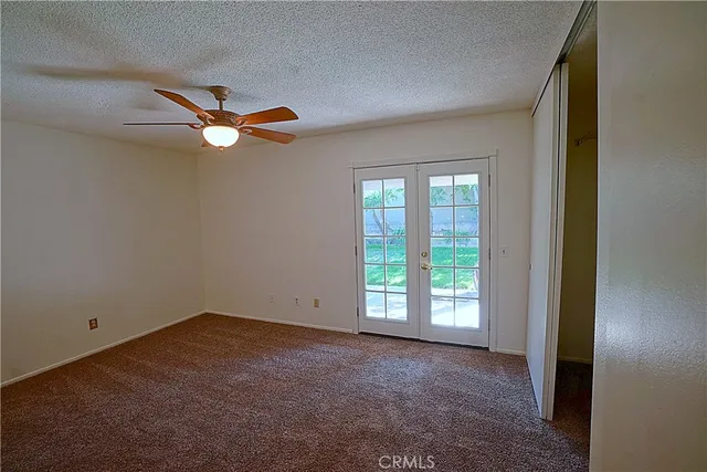 an empty room with windows and fan