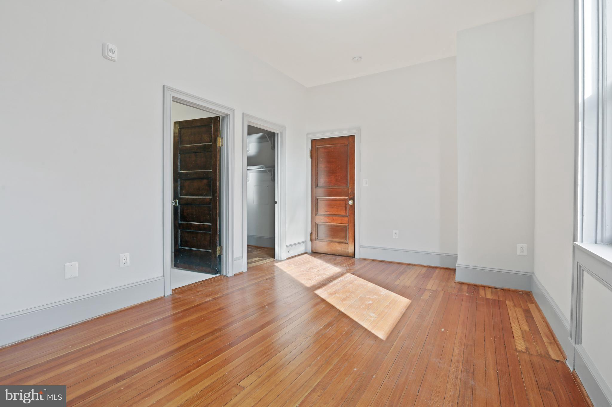 812 Park Avenue, Unit 3FF Baltimore, MD 21201 - Photo 12 of 17 an empty room with wooden floor and windows