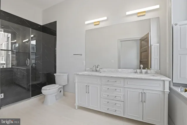 a bathroom with a granite countertop sink toilet and shower