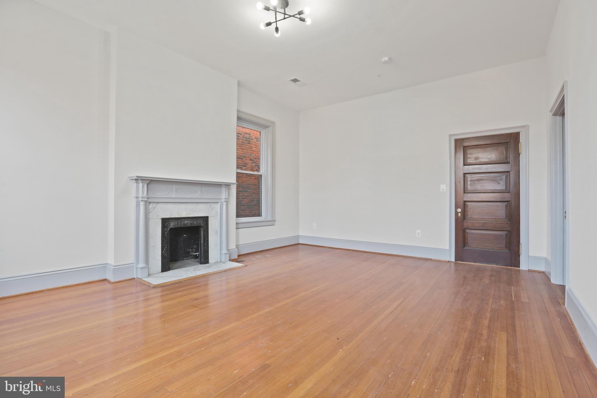 812 Park Avenue, Unit 3FF Baltimore, MD 21201 - Photo 6 of 17 a view of empty room with wooden floor and fireplace