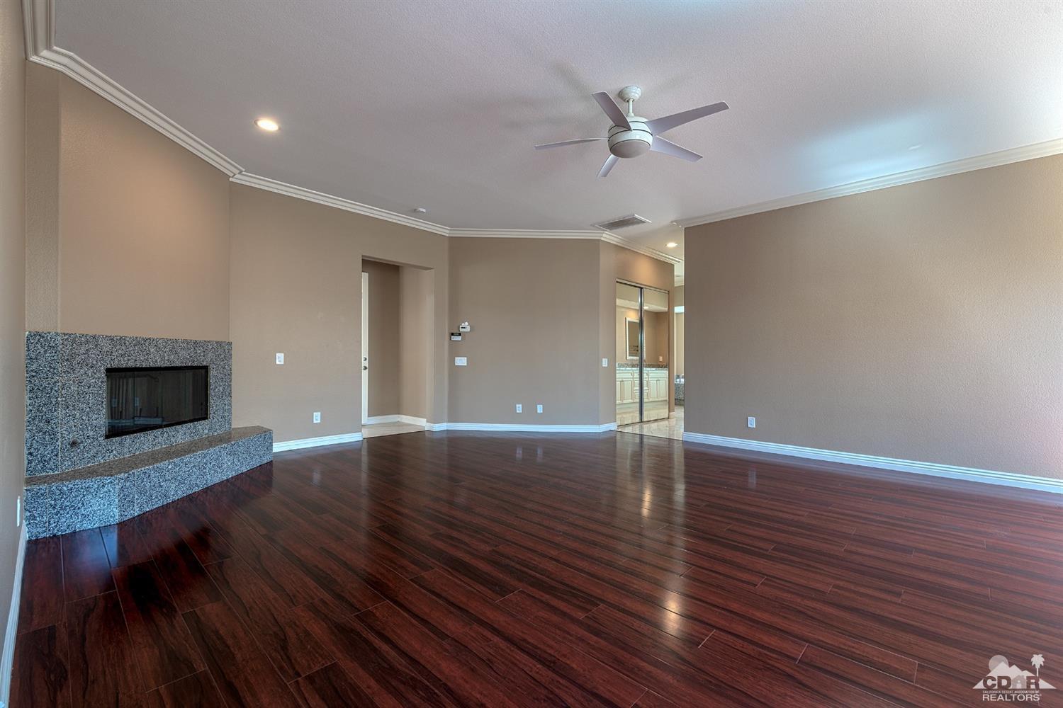 35 Sherwood Road Rancho Mirage, CA 92270 - Photo 12 of 25 an empty room with wooden floor and a ceiling fan