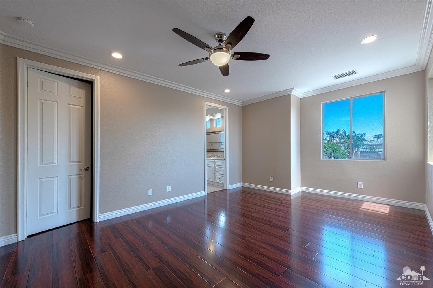 35 Sherwood Road Rancho Mirage, CA 92270 - Photo 22 of 25 a view of an empty room with wooden floor and a ceiling fan