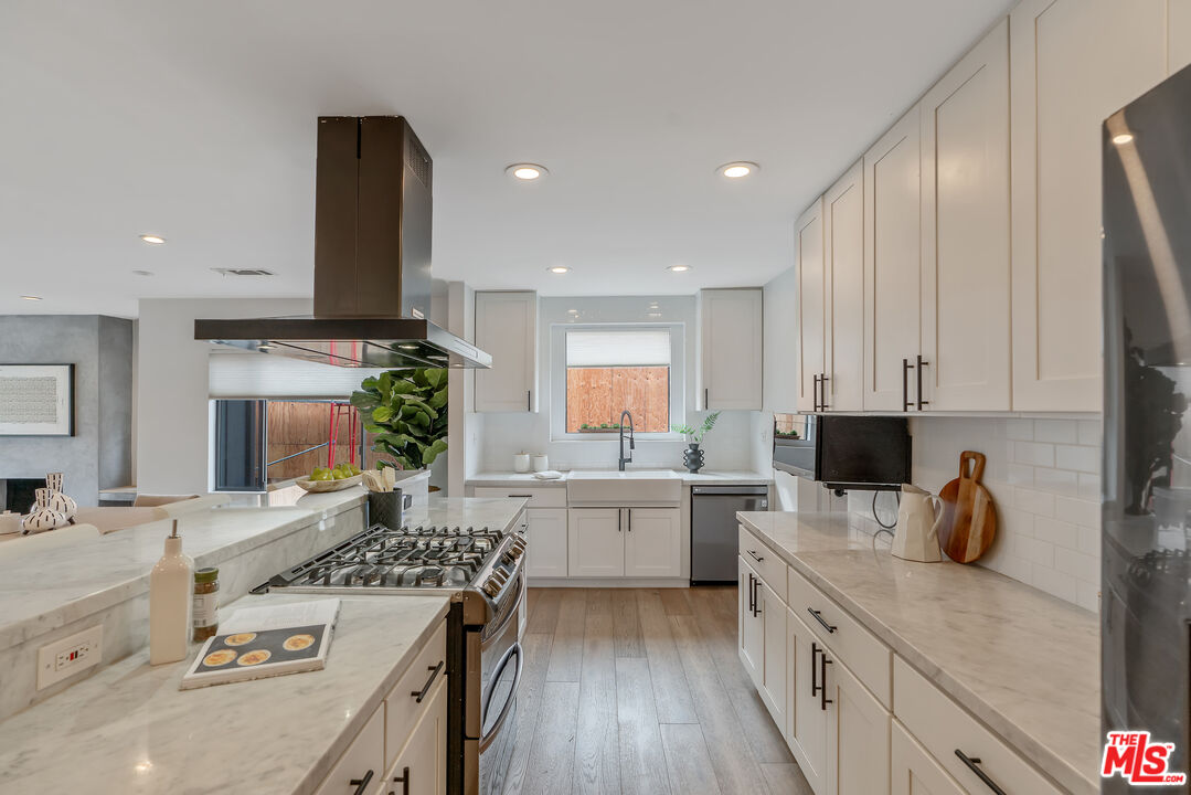 1645 South Sierra Bonita Avenue Los Angeles, CA 90019 - Photo 20 of 62 a kitchen with a sink stove and cabinets