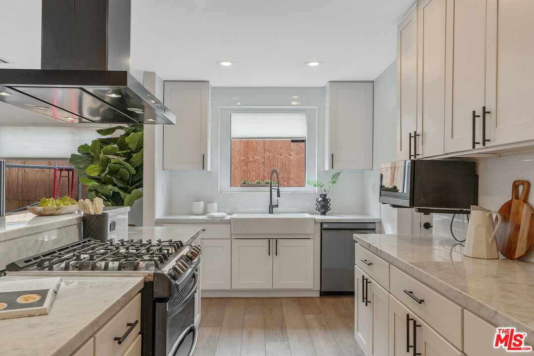 1645 South Sierra Bonita Avenue Los Angeles, CA 90019 - Photo 21 of 62 a kitchen with a sink stove and cabinets