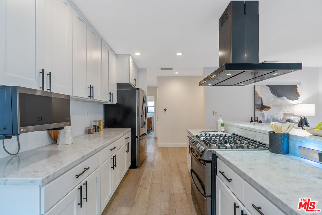 1645 South Sierra Bonita Avenue Los Angeles, CA 90019 - Photo 22 of 62 a kitchen with a sink stove and refrigerator
