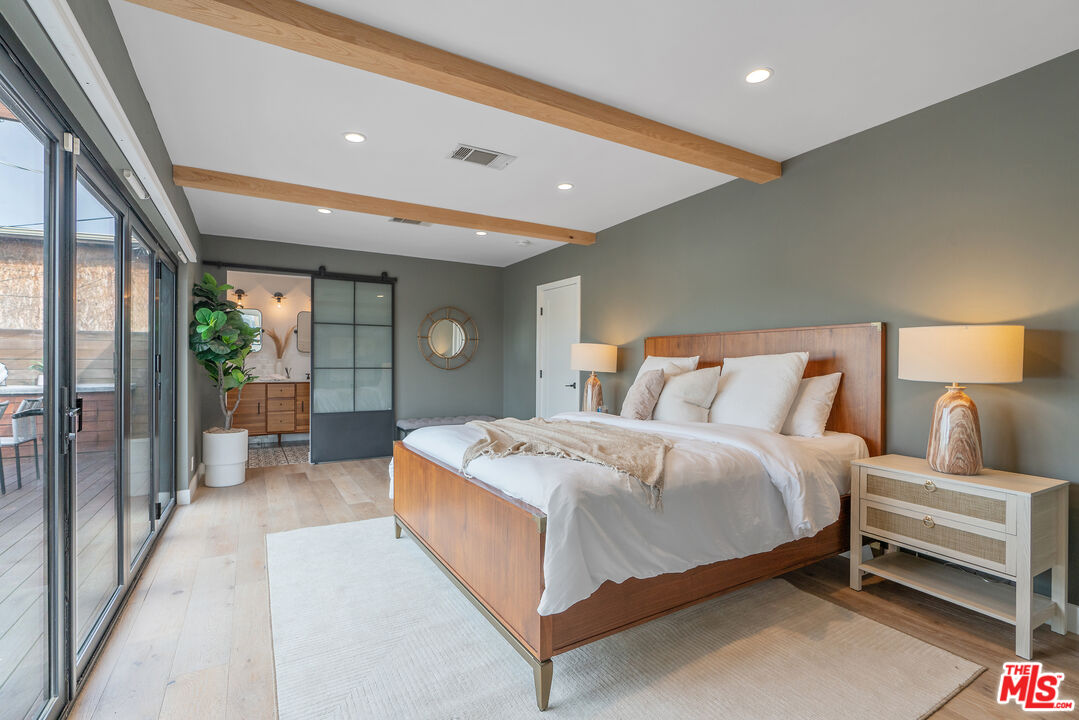 1645 South Sierra Bonita Avenue Los Angeles, CA 90019 - Photo 31 of 62 a spacious bedroom with a bed and glass door