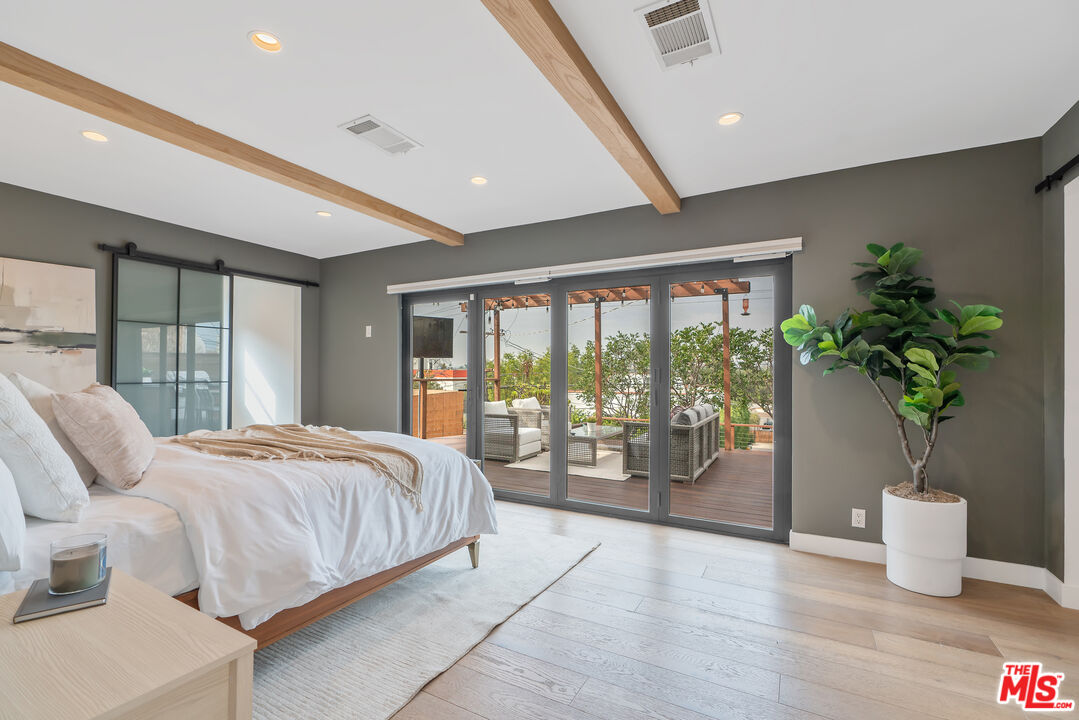 1645 South Sierra Bonita Avenue Los Angeles, CA 90019 - Photo 33 of 62 a bedroom with a large bed and a potted plant