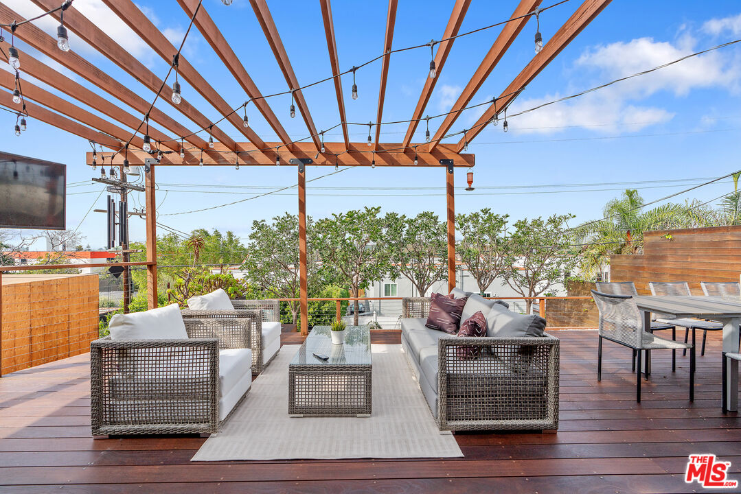 1645 South Sierra Bonita Avenue Los Angeles, CA 90019 - Photo 41 of 62 a living room with patio furniture and a flat screen tv