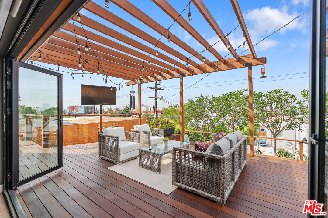 1645 South Sierra Bonita Avenue Los Angeles, CA 90019 - Photo 42 of 62 a outdoor space with patio the couches and potted plants with wooden floor