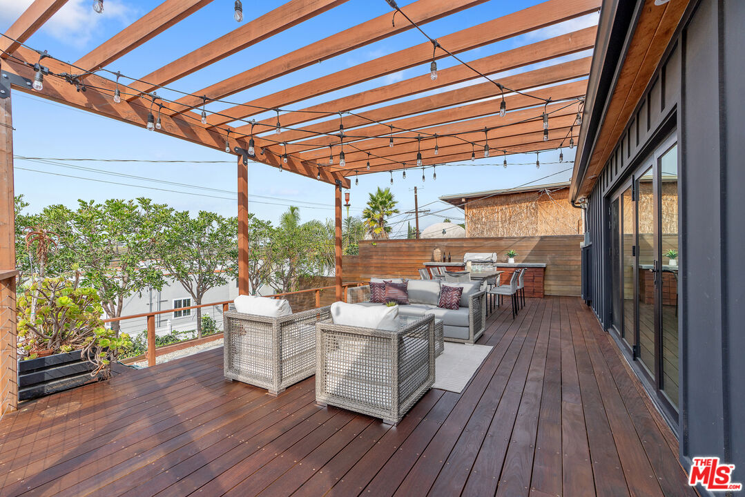 1645 South Sierra Bonita Avenue Los Angeles, CA 90019 - Photo 43 of 62 a view of a patio with table and chairs and wooden floor