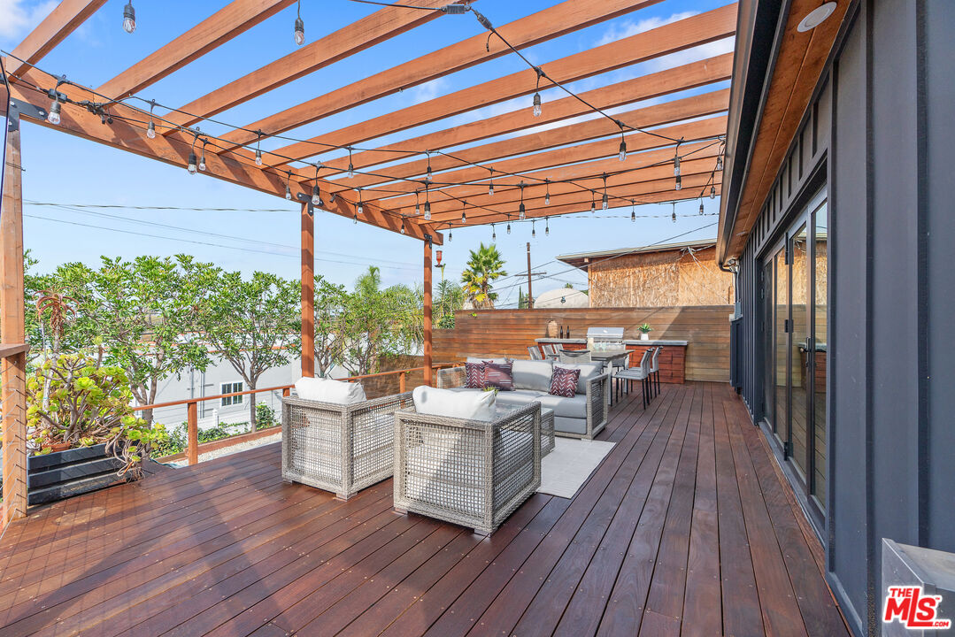 1645 South Sierra Bonita Avenue Los Angeles, CA 90019 - Photo 47 of 62 a view of a patio with table and chairs barbeque with wooden floor