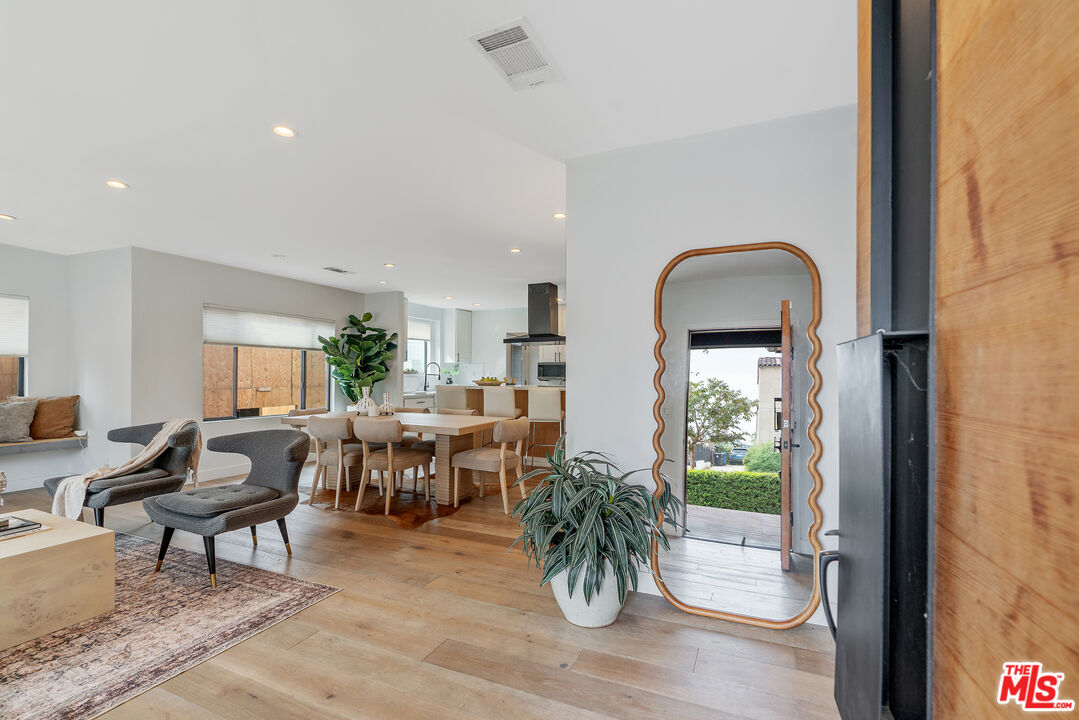 1645 South Sierra Bonita Avenue Los Angeles, CA 90019 - Photo 5 of 62 a living room with furniture a potted plant and open to view of kitchen