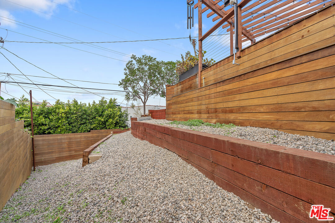 1645 South Sierra Bonita Avenue Los Angeles, CA 90019 - Photo 53 of 62 a yellow house with flower garden in front of it