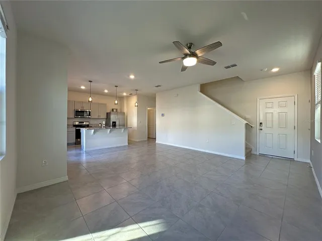 a view of empty room with a kitchen