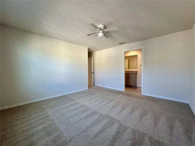 an empty room with closet and a ceiling fan