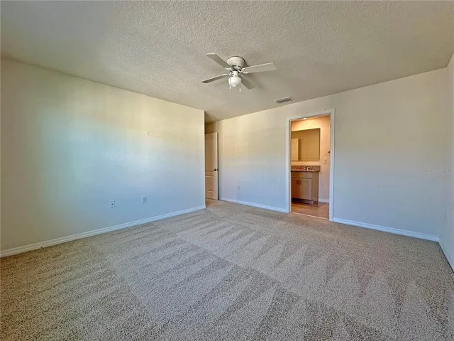 an empty room with closet and a ceiling fan