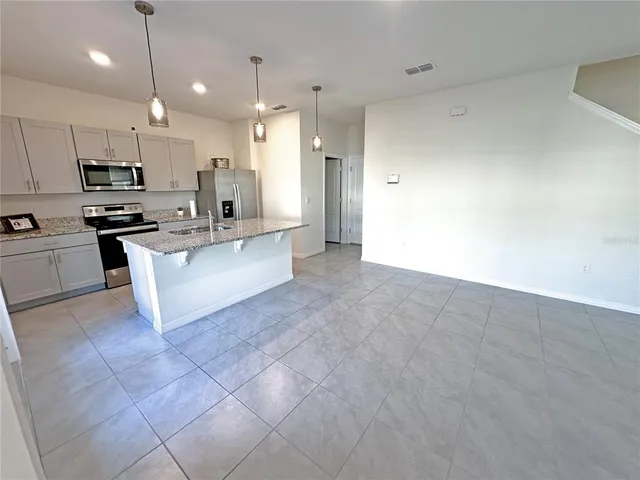 a large white kitchen with a stove a sink and a refrigerator