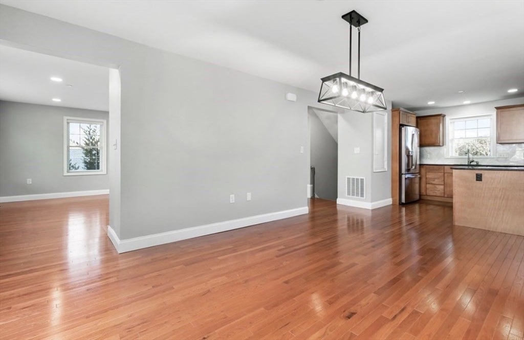 38 Webster Street, Unit 2 Needham, MA 02494 - Photo 2 of 16 a view of a room with wooden floor kitchen chandelier and windows
