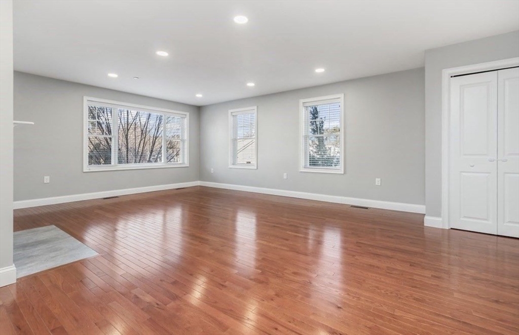 38 Webster Street, Unit 2 Needham, MA 02494 - Photo 4 of 16 an empty room with wooden floor and windows