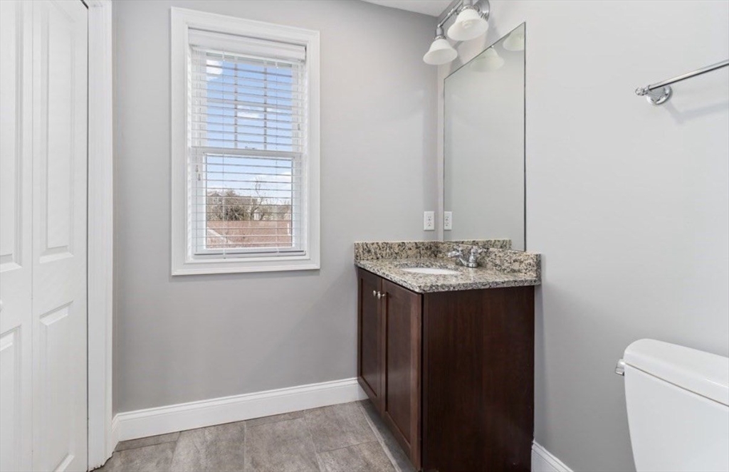 38 Webster Street, Unit 2 Needham, MA 02494 - Photo 8 of 16 a bathroom with a granite countertop sink and a toilet