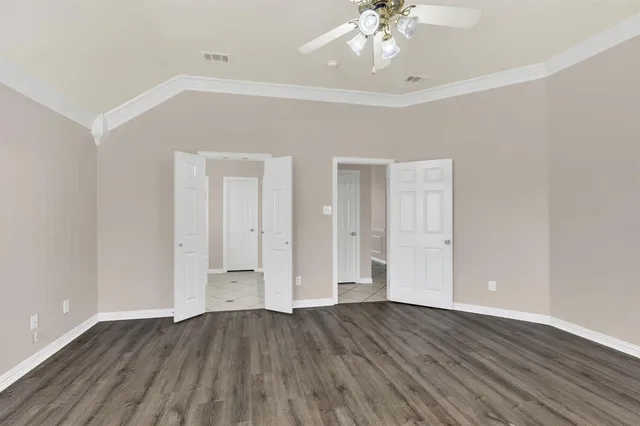 an empty room with wooden floor and chandelier