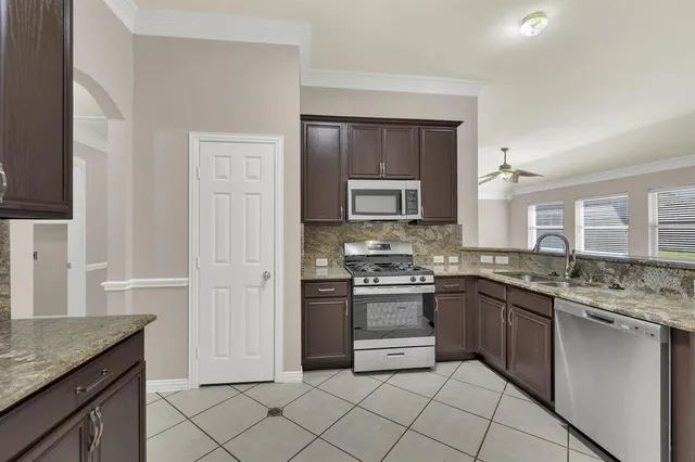 a kitchen with stainless steel appliances granite countertop a sink and stove top oven