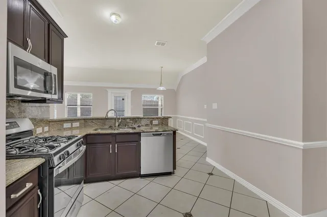 a kitchen with stainless steel appliances granite countertop a stove and a sink
