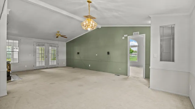 en empty room with windows and chandelier