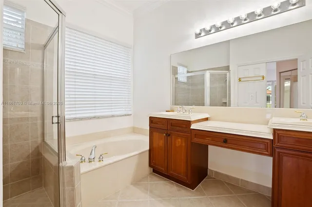 a spacious bathroom with a tub sink and mirror