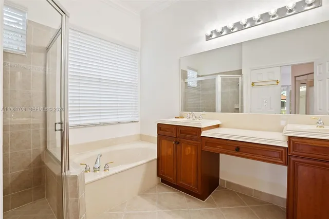a spacious bathroom with a tub sink and mirror