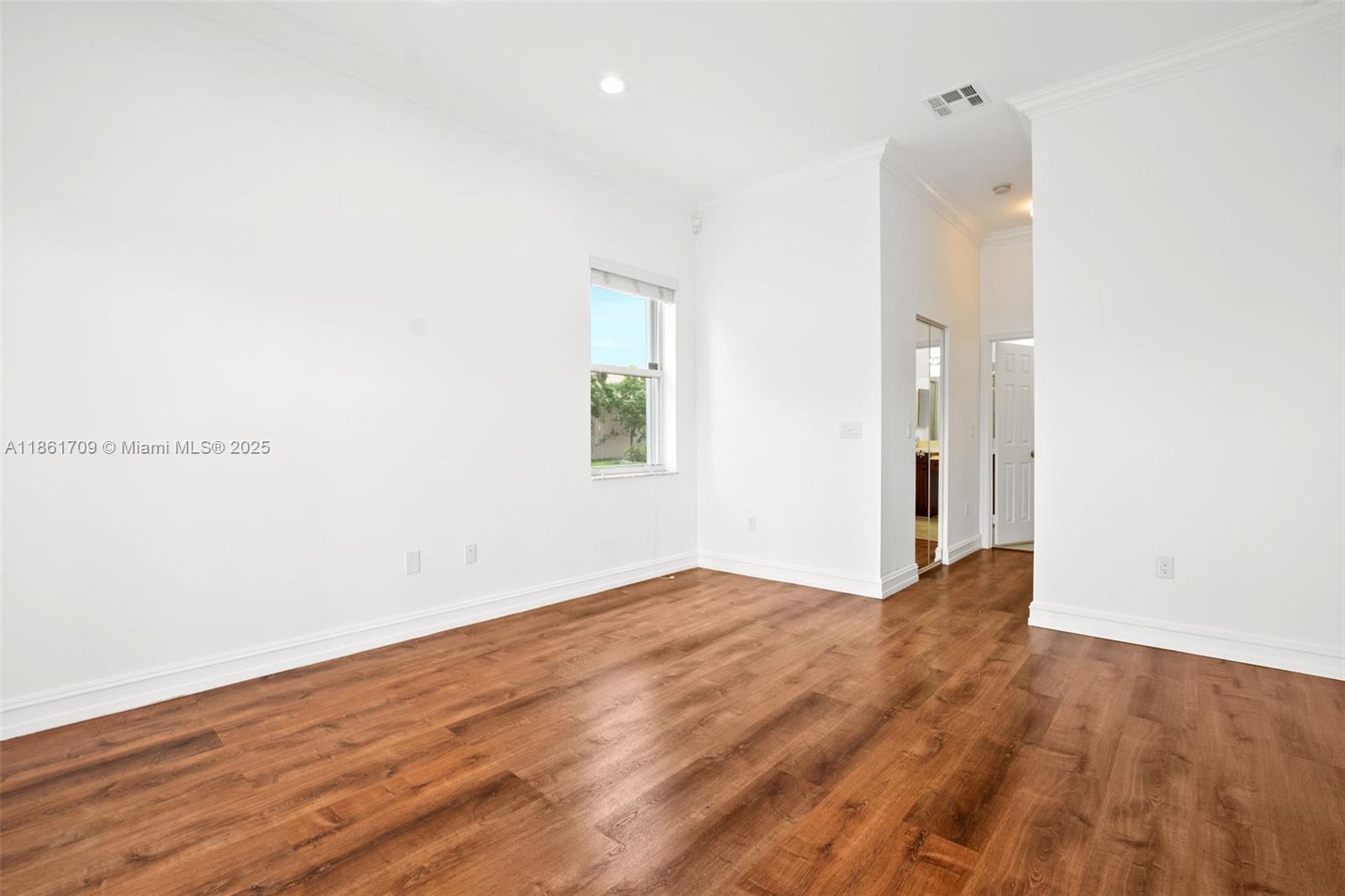 5168 Southwest 157th Avenue Miramar, FL 33027 - Photo 18 of 30 an empty room with wooden floor and windows