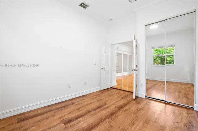 an empty room with wooden floor and a window
