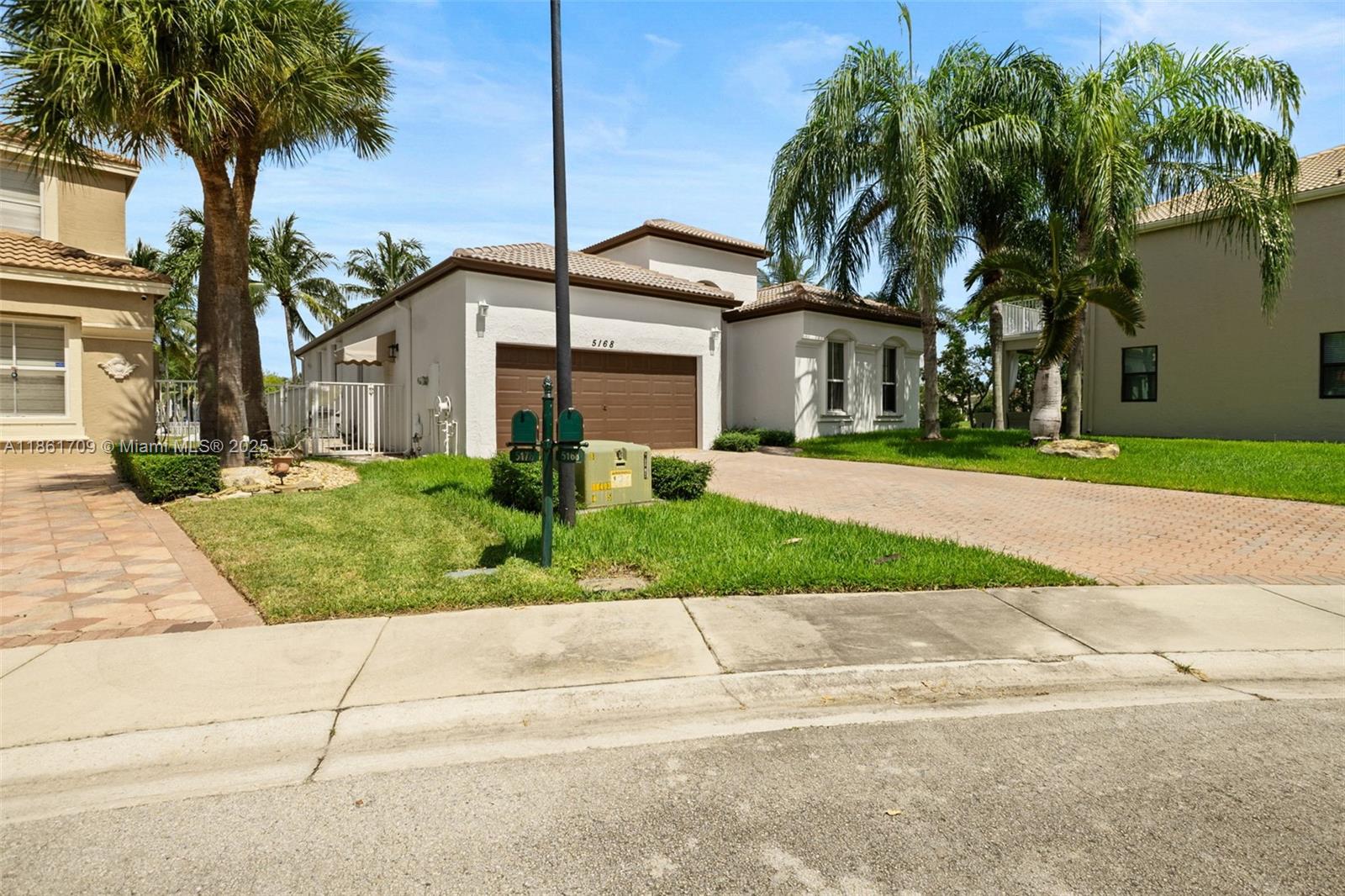 5168 Southwest 157th Avenue Miramar, FL 33027 - Photo 2 of 30 a front view of a house with a garden and trees