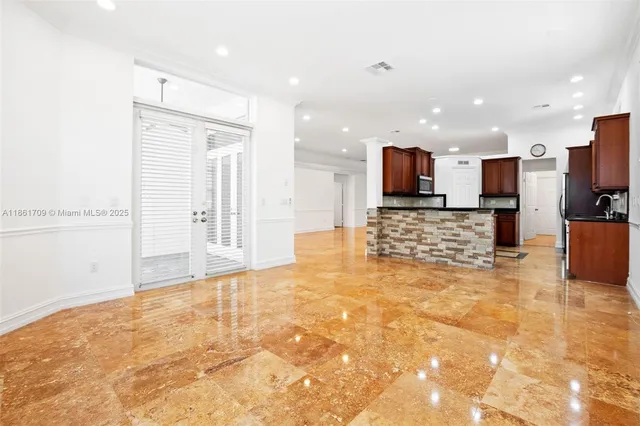 a view of kitchen and kitchen with granite countertop cabinets
