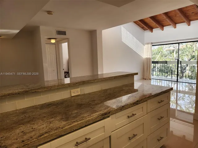 a kitchen with granite countertop cabinets and window