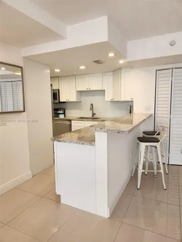 a kitchen with a sink a table and chairs in it